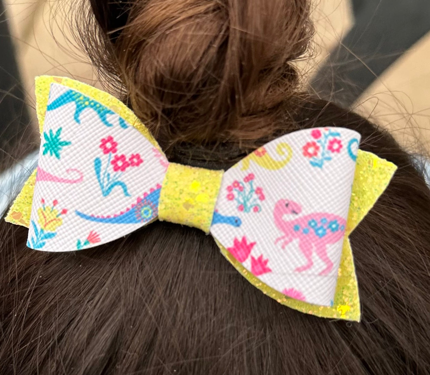 Multicolored Dinosaurs on yellow glitter hair bow