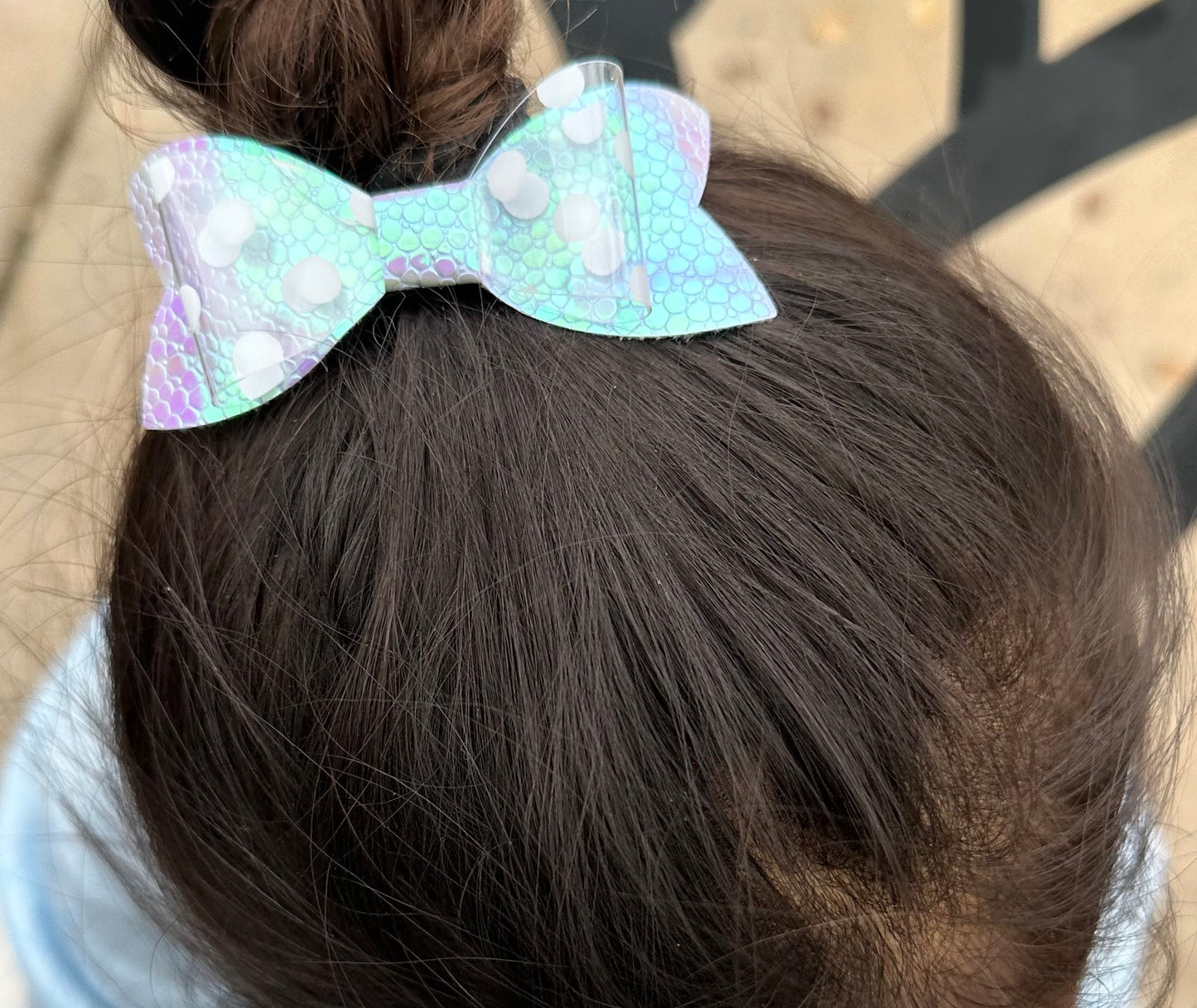 White polka dots on holographic purple scales bow